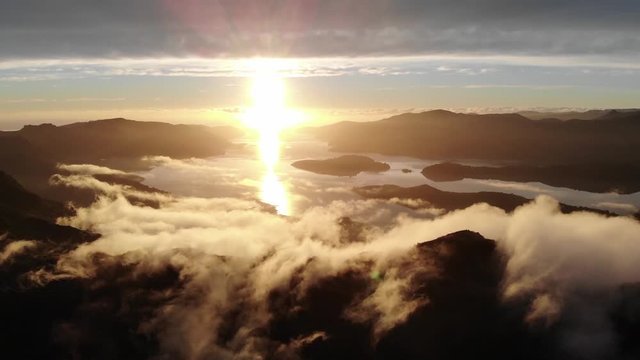 Aerial - Orange clouds forming on a ridge at sunrise from above