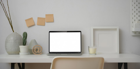 Obraz premium Minimal workspace with blank screen laptop computer with mock up frame and decorations