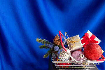 Festive basket with gifts and Christmas toys close up on a bright blue background