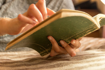 Young woman having rheumatoid is reading a book. Hands and legs are deformed. She feels pain. Selective focus.