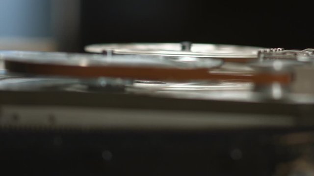 Running tape on reel in old vintage tape recorder rack focus close up