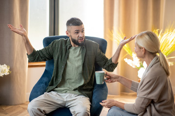 Bearded man feeling really emotional while telling about his wife
