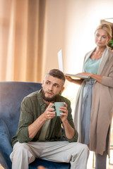 Patient sitting in armchair and listening to psychologist