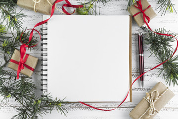 Notepad with fir tree branches on table