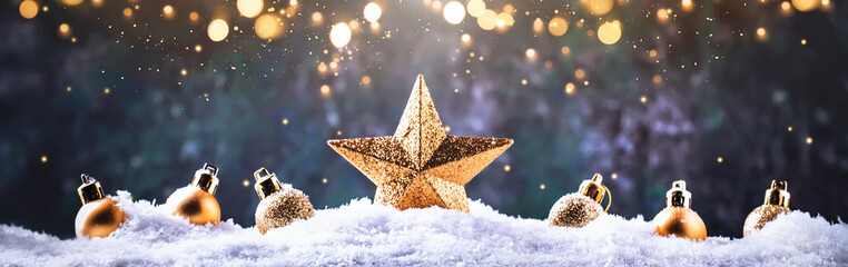 Fototapeta Christmas background with golden star. New Year's decor. Christmas balls in smowdrifts and golden bokeh lights obraz