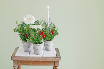 Simple table decoration for Christmas with gerbera flowers and fir twigs.