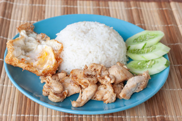 Fried chicken with garlic, Fried egg and Rice in blue plate on wooden table.