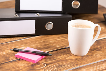 business desk with coffee cup, folder, paper and pen