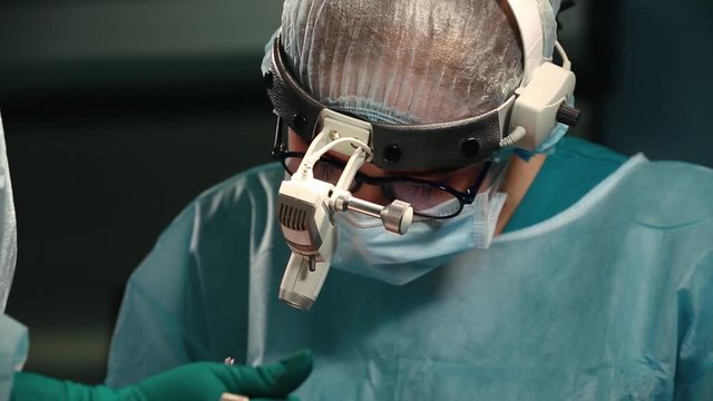A team of surgeons has a major plan during surgery, a blue light operating room, a rhinoplasty operation to improve the aesthetics of the nose. Medetsina, plastic surgery.