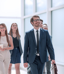 businessman walking in front of his business team