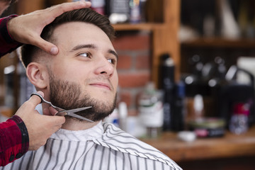 Barber shaving beards man in barber shop