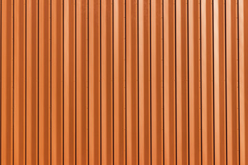 Building with wall of orange metal. Corrugated texture, galvanized steel surface. Abstract architectural pattern for background with copy space