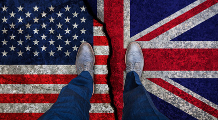 Business man stands on cracked flag of UK and USA. Political concept