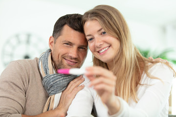 smiling couple looking at pregnancy test