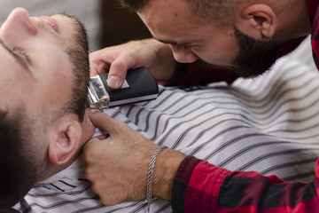 Obraz premium Close-up man in barber shop shaving