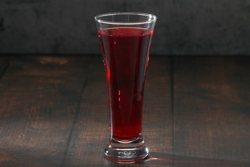 Red juicy drink in a high beer glass	