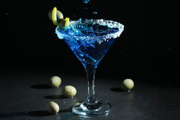 A glass with blue martini cocktail	