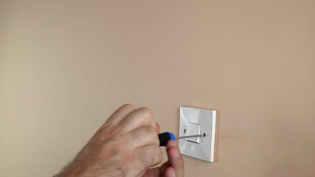 Detaching light switch from a wall with a screwdriver