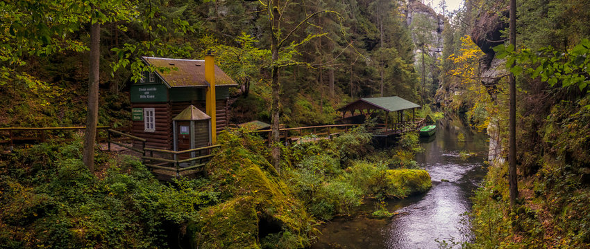 The Kamnitz Gorge - entrance (cabin, shed and boat) to the river port by the river flowing through rocky ravine in Bohemian Switzerland, Czech republic