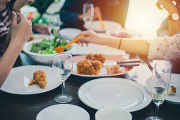 Dinner with Asian Group of best friends enjoying evening drinks while sitting at the dinning table on the kitchen together