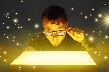 Astonished man looking inside a glowing parcel