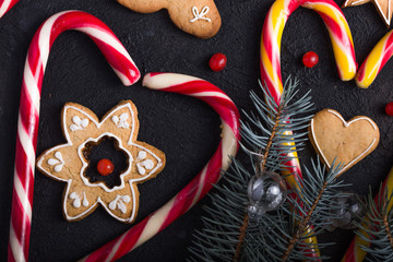 New Year and Christmas background. Christmas candy cane gingerbread on black background. New Year and Christmas composition, free space for text, New year and Christmas still life
