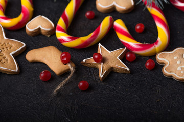 New Year and Christmas background. Christmas candy cane gingerbread on black background. New Year and Christmas composition, free space for text, New year and Christmas still life