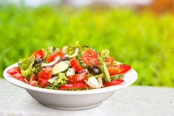 Photo of fresh salad with colorful vegetables in white plate