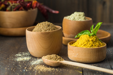 Heaps of various ground spices on wooden background. Georgian spices, Indian spices, Arabian spices. Spice variety. Herbs and spices