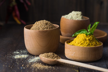Heaps of various ground spices on wooden background. Georgian spices, Indian spices, Arabian spices. Spice variety. Herbs and spices