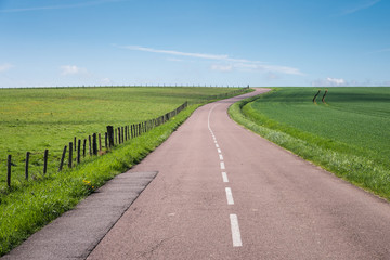 une route part vers l'horizon dans la campagne