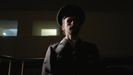 Military officer siting in a dark room