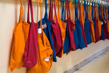 des sacs en tissus dans une école. Des cartables dans le couloir d'une école. Des sacs de tissus colorés aux porte-manteaux d'une école maternelle. - obrazy, fototapety, plakaty