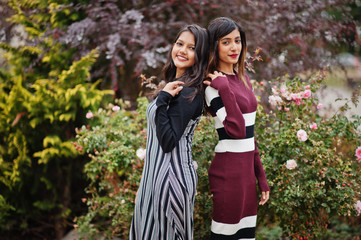 Portrait of two young beautiful indian or south asian teenage girls in dress.