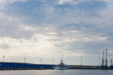 Fototapeta na wymiar Large white yacht parked on the background of dock