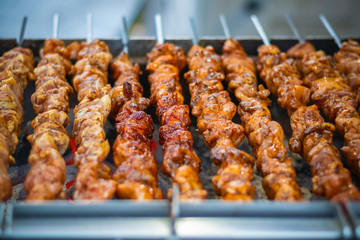 Selective focus, chicken kebabs cooking on a charcoal grill at Christmas market winter wonderland in London