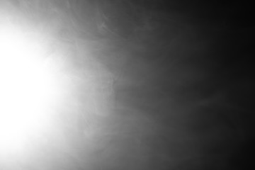 White smoke on a black background in the spotlight