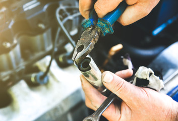Man holding spark plug in old car engine. Inner details of machine. Repairing of vehicle.