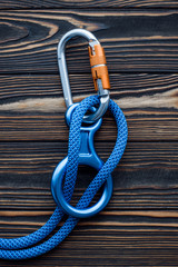Simple lock. Isolated photo of climbing equipment. Parts of carabiners lying on the wooden table