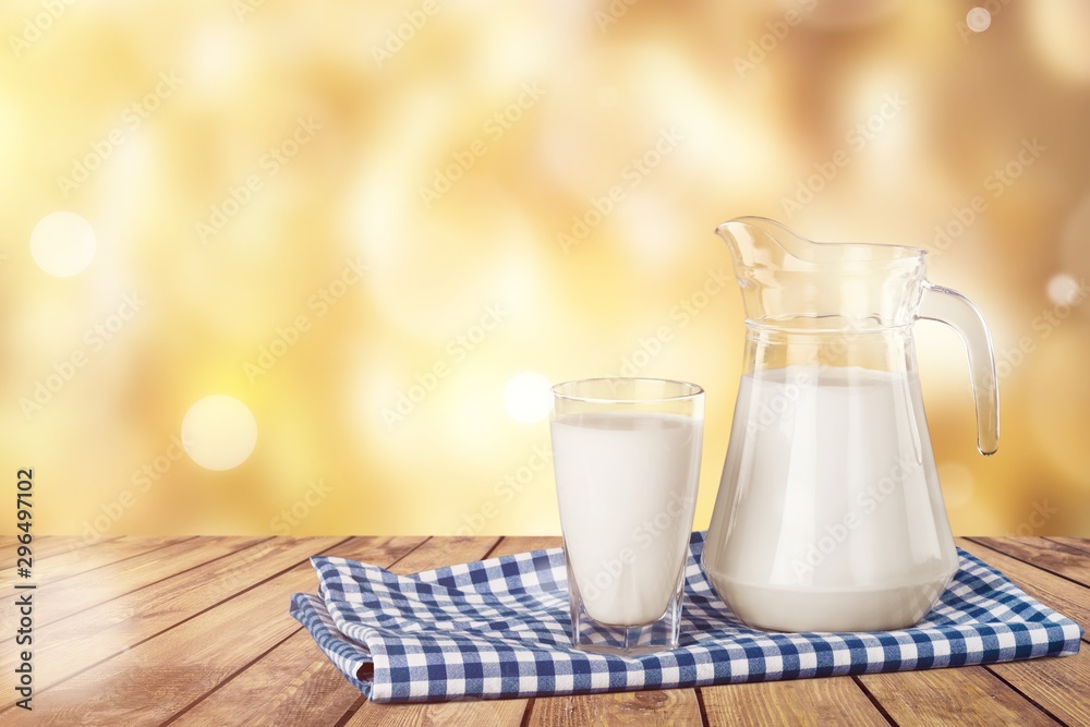 Sticker A glass of milk and a milk jug on plaid tablecloth