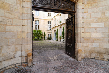 Entrance wood door with knocker in Bordeaux city classic French private mansion house