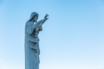 Statue of Jesus at Notre Dame in Marseille against a clear blue sky. Side view.