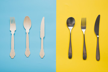 Comparison of reusable metal cutlery, and eco wooden spoon, knife. View from above. Top view. Flat lay.