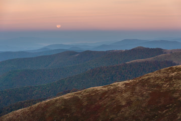Moonlight in the Ukrainian Carpathians on a mountain ridge with a red tourist tent