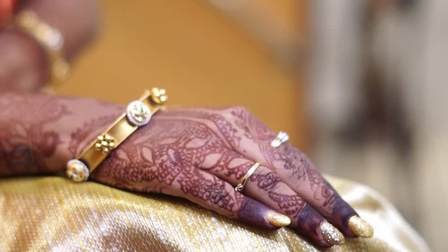 Bride's hand with henna and ornaments