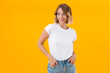 Image of lovely woman in basic t-shirt smiling and looking aside