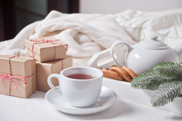 Cup of tea, homemade cookies, Christmas gift boxes and Christmas decor on the white background.