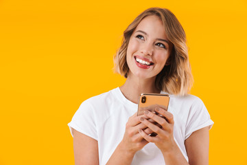 Image of caucasian blond woman looking upward and holding cellphone