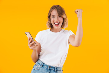 Image of optimistic woman screamng as winner and holding cellphone