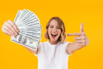 Fotobehang Image of excited blond woman holding bunch of money cash © Drobot Dean